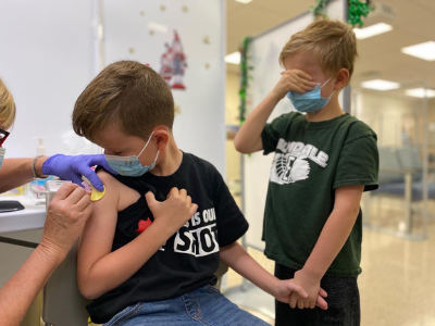 a child gets his first COVID-19 vaccine at QCH